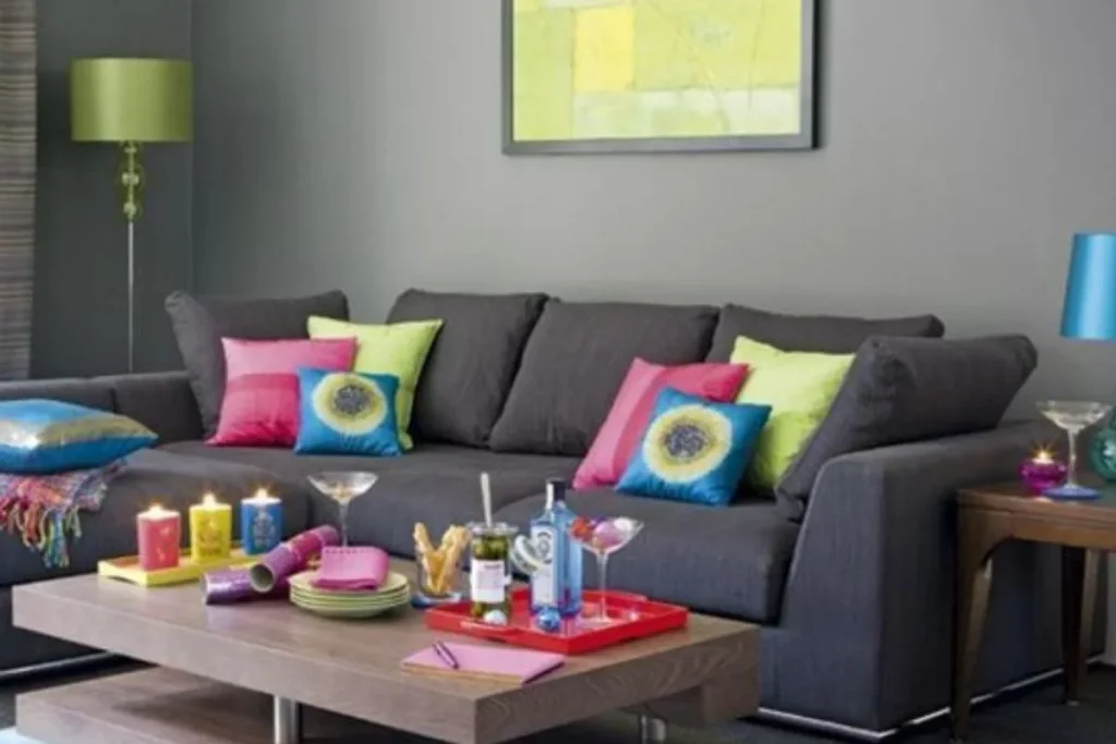 Sofá cinza com almofadas em tons vibrantes para um contraste moderno.